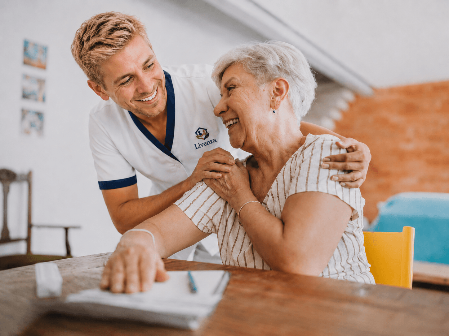 Zorgmedewerker bij een bewoner in de kamer